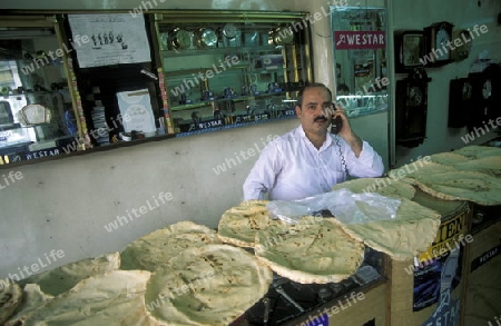 Fladenbrot wird in einem Uhrenladen getrocknet auf dem Souq oder Markt in der Medina der Altstadt von Aleppo im Norden von Syrien im Nahen Osten.  