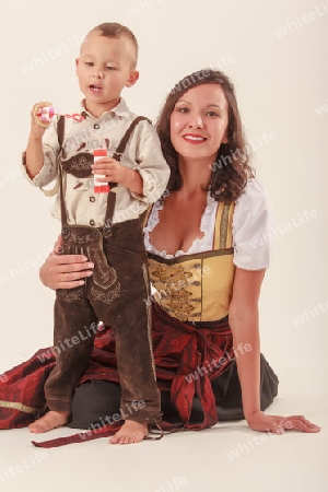 Bayerische Mutter in Tracht mit Ihrem Sohn beim spielen