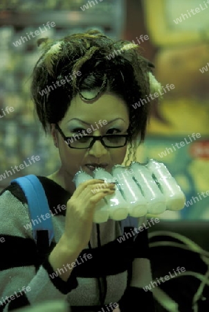 a women with drinks in a suppermarket in the city of Chongqing in the province of Sichuan in china in east asia. 