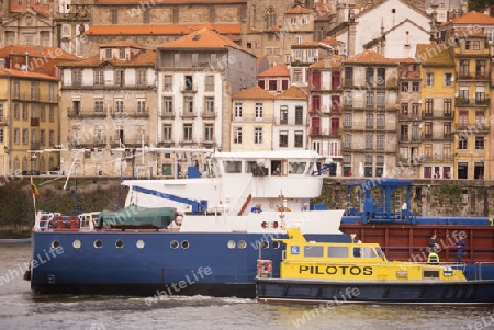 a transport ship at the waterfront with the old town on the Douro River in Ribeira in the city centre of Porto in Porugal in Europe.