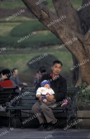 a father with his baby in a parc in the city of Chongqing in the province of Sichuan in china in east asia. 