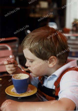 kleiner Junge trinkt Cappucino