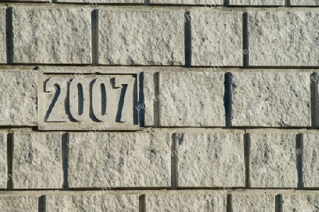 Graue Bruchsteinmauer mit der Erbauungsmarke 2007 an der linken Seite.