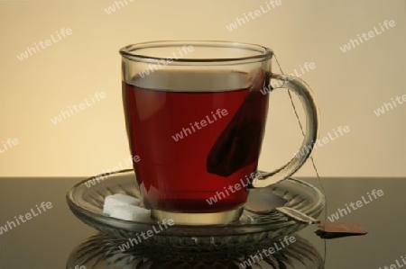Teeglas auf Unterteller, mit Zucker und L?ffel, und roten Tee gef?llt.
