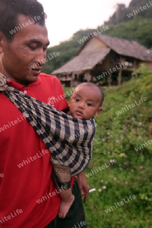 Ein Vater mit seinem Babyt bei Vang Vieng in der Bergregion der Nationalstrasse 13 zwischen Vang Vieng und Luang Prabang in Zentrallaos von Laos in Suedostasien.  