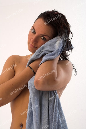 Frau trocknet nach dem Duschen die Haare
