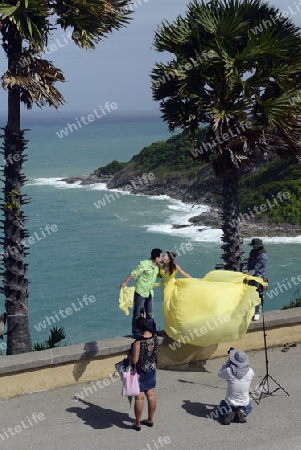 Ein Hochzeitspaar bei einem Fototermin am Aussichtspunkt Kap Promthep bei der Rawai Beach im sueden der Insel Phuket im sueden von Thailand in Suedostasien.