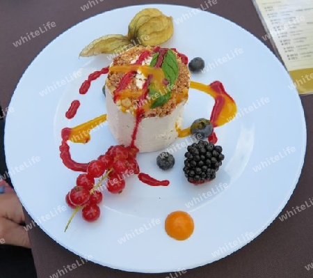 Eis verziert mit Fr?chten, Nusssplittern, Minze und verschiedenen Fruchtso?en - Ice cream with decoration of fruits, nut slivers, mint, and a potpourri of sauces
