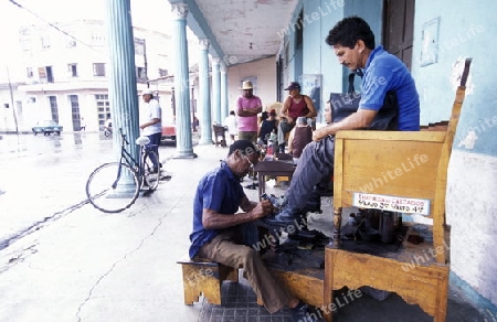 a shoe cleaner in the city of las Tunas on Cuba in the caribbean sea.