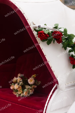 Blumen auf rotem Sitz einer Hochzeitskutsche
