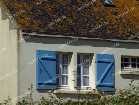 Vorderfront eines Hauses mit hellblauen Fensterlaeden