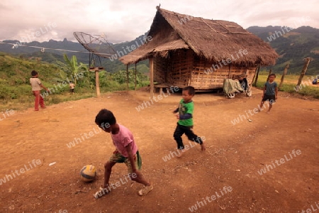 Kinder beim Fussball Spielen in einem Bergdorf in der Bergregion beim Dorf Kasi an der Nationalstrasse 13 zwischen Vang Vieng und Luang Prabang in Zentrallaos von Laos in Suedostasien. 