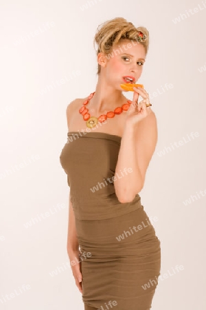 Attraktive blonde junge Frau mit Erdbeere-Kiwi 