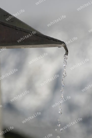 Dachrinne mit fallendem Wasser, Hintergrund unscharf