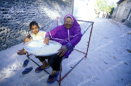 Asien, Indischer Ozean, Malediven,
Eine Alte Frau beim Reise reinigen in einer Gasse einer Einheimischen Insel der Inselgruppe Malediven im Indischen Ozean 





