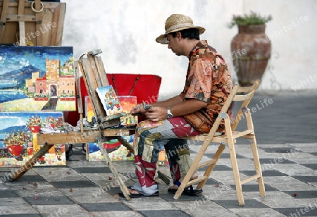 a Painter in the old Town of  Taormina in Sicily in south Italy in Europe.