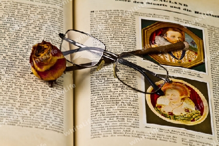 Buch mit Rose und Brille