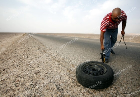 A flat tire on a Taxi on the Desertroad 65 near the Towns Safi and Aqaba in Jordan in the middle east.