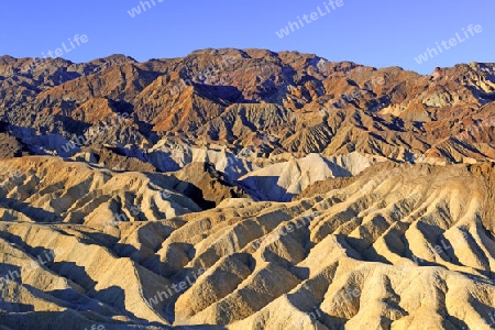 farbige Gesteinsformationen bei Sonnenaufgang am Zabriske Point, Death Valley Nationalpark, Kalifornien, USA