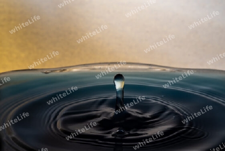 Highspeed Fotografie mit eingefärbtem Wasser und gelben Hintergrund