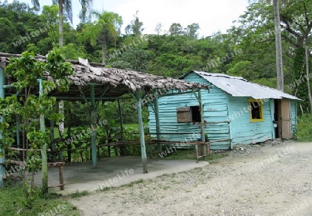 Dominikanische Republik, Holzhaus am Schotterweg