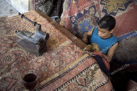 Eine Teppichknuepferei auf dem Souq oder Markt in der Medina der Altstadt von Aleppo im Norden von Syrien im Nahen Osten