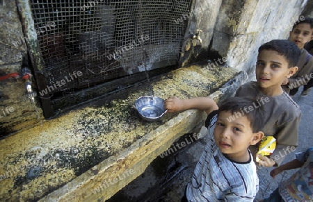 Kinder vor einem Wasserbrunnen in der Altstadt von Aleppo im Norden von Syrien im Nahen Osten.