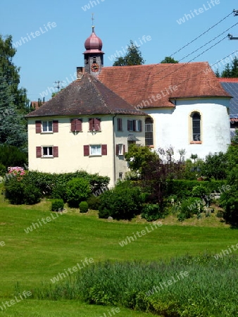 Dorfkirche mit Pfarrhaus und gr?ne Wiese im Vordergrund
