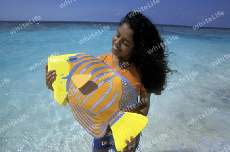Eine Einheimische Frau an einem Traumstrand auf einer Touristen Insel auf dem Malediven im Indischen Ozean.