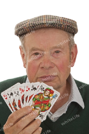 Senior mit Spielkarten auf hellem Hintergrund
