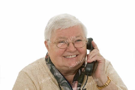 Seniorin beim telefonieren auf hellem Hintergrund