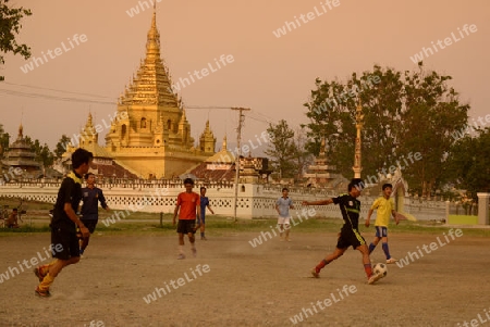 soccer player in soccer field in front of the Yadana Man Aung Pagoda in the town of Nyaungshwe at the Inle Lake in the Shan State in the east of Myanmar in Southeastasia.