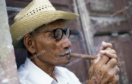 a signor with a cigar in the city of Santiago de Cuba on Cuba in the caribbean sea.