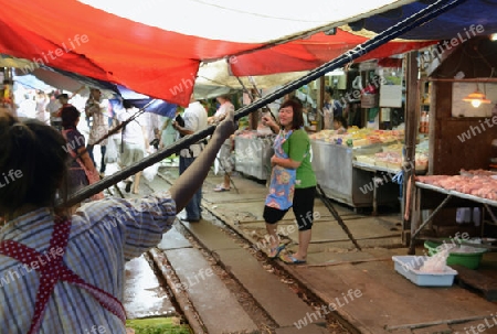 Der Maeklong Railway Markt beim Maeklong Bahnhof ausserhalb der Hauptstadt Bangkok von Thailand in Suedostasien.