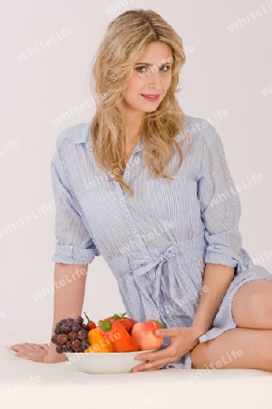 Sch?ne junge Frau beim Obst essen 