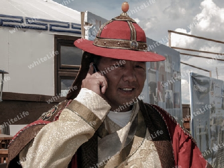 mongolei_mongole in traditioneller kleidung mit mobiltelefon
