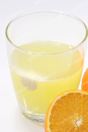 Orange mit einem Glas und Brausetabletten auf hellem Hintergrund