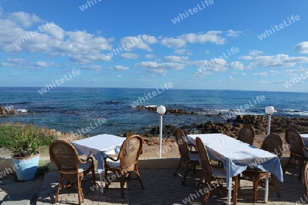 Tische und Stühle am Meer