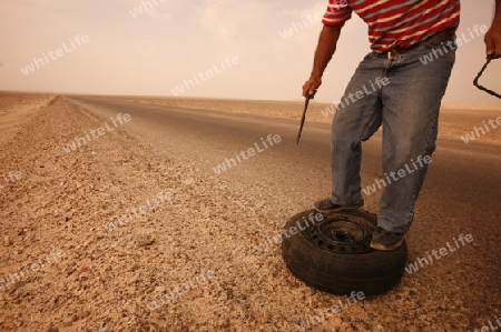 A flat tire on a Taxi on the Desertroad 65 near the Towns Safi and Aqaba in Jordan in the middle east.