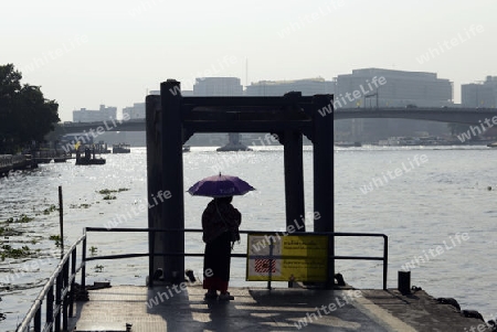 Eine Frau wartet auf ein Boot am Mae Nam Chao Phraya River in der Hauptstadt Bangkok von Thailand in Suedostasien.