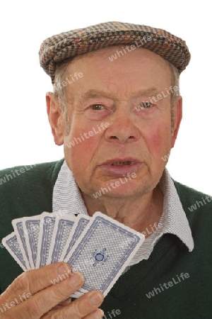 Senior mit Spielkarten auf hellem Hintergrund