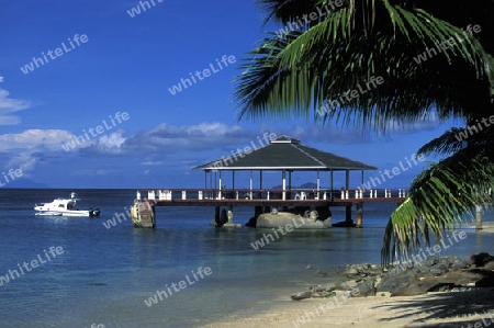 Ein Hotelstrand mit Pavillon bei Sonnenuntergang auf der Insel Praslin auf den Seychellen im Indischen Ozean.