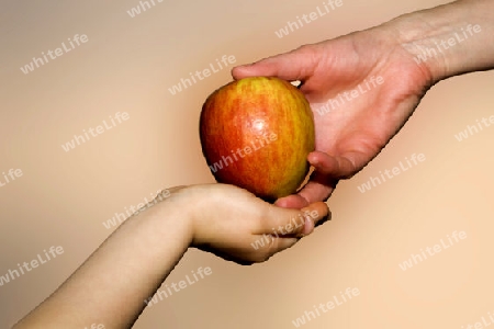 Hand der Mutter und das Kind mit dem Apfel