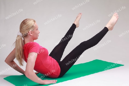 Junger Mann/Frau macht Yoga auf einer Gymnastikmatte