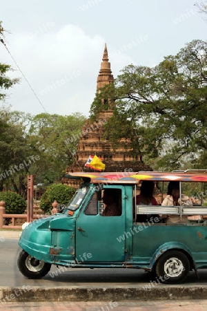 Ein Taxi vor einem der vielen Tempel in der Tempelstadt Ayutthaya noerdlich von Bangkok in Thailand. 