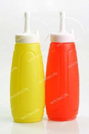 Senf und Ketchup Flaschen auf hellem Hintergrund