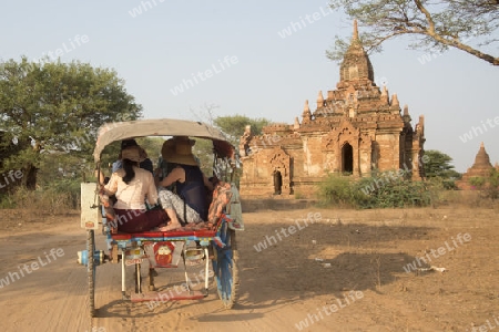 Tourists in a Horsecart Taxi in front Temple and Pagoda Fields in Bagan in Myanmar in Southeastasia.
