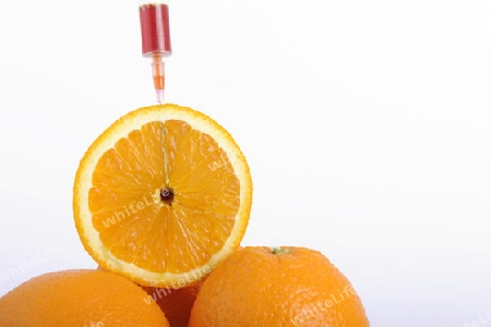 Spritze in Orange, Genorange, Symbolbild, Injektionsspuren in der Orange, genmanipulierte Lebensmittel