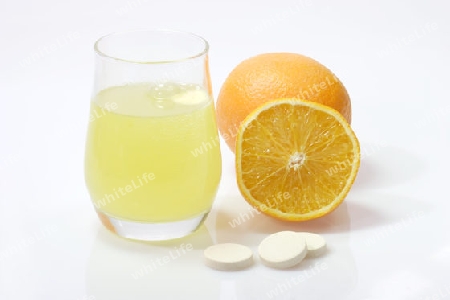 Orange mit einem Glas  und Brausetabletten auf hellem Hintergrund