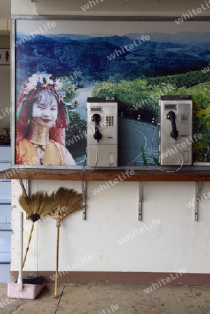 Telefone mit einem Bild einer Longneck Frau auf dem Flugplatz in Pai im norden von Thailand in Suedostasien.